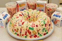 a bundt cake is decorated with multicolored squares and frosting next to milk