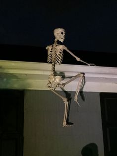 a skeleton hanging from the side of a building