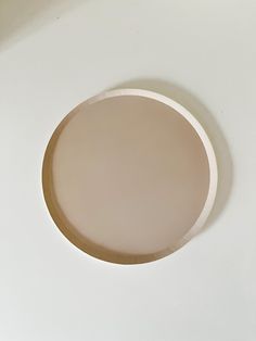 a white wall with a round mirror on it