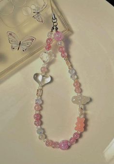 a white plate topped with a pink and clear beaded necklace