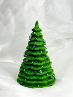 a crocheted christmas tree sitting on top of a white sheet