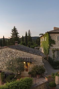 an aerial view of a stone building with potted plants and trees in the foreground