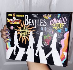 a person holding up a book with the beatles on it