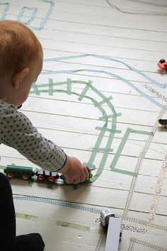 a toddler playing with toy trains on the floor