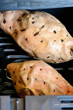 two sweet potatoes sitting on top of an open oven door, with holes in them