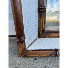 an old wooden framed mirror sitting on the ground