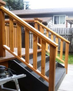 a wooden staircase with handrails and steps leading up to the back yard area