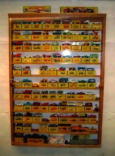 there is a display case with many toy cars and trucks on the shelves in front of it