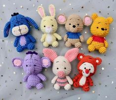 small crocheted stuffed animals are arranged on a sheet