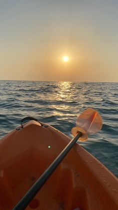 the sun is setting over the ocean from a kayak in the middle of the water