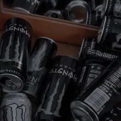 several cans of monster energy drink are stacked on top of each other in a bin