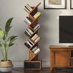 a tall wooden book shelf sitting next to a tv on top of a hard wood floor