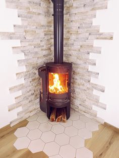 a wood burning stove in a room with white tiles on the walls and flooring