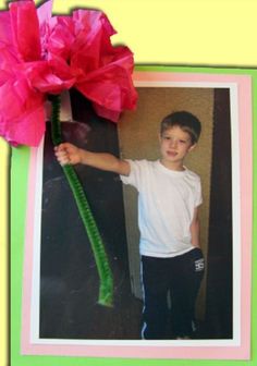 a young boy holding a pink flower on top of a green and yellow frame with the photo of him