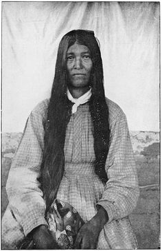 an old black and white photo of a woman with long hair