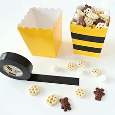 a paper bag filled with cereal next to a black tape and some other things on the table