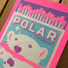 a pink and blue polar t - shirt sitting on top of a wooden table next to toothbrushes