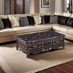 a living room with a large sectional couch and coffee table in the middle, along with zebra print pillows