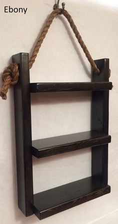 a wooden shelf with rope hanging from it's sides and the bottom part of it