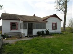 an old white house with red trim and windows