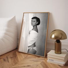 a black and white photo sitting on top of a wooden floor next to a lamp