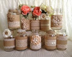 there are many jars with lace and flowers in them