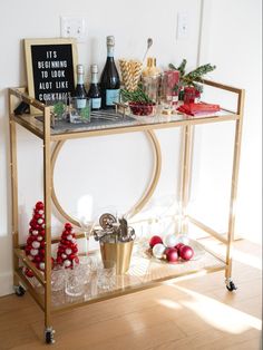 a bar cart filled with christmas decorations and wine bottles