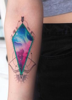 a woman's arm with a colorful diamond tattoo on the left side of her body