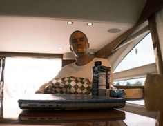 a man sitting at a table in front of a laptop with a bag on it