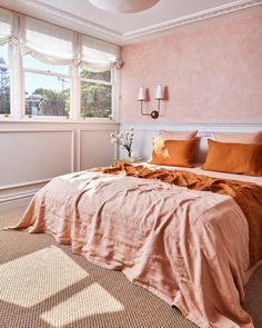 a large bed sitting in a bedroom next to a window