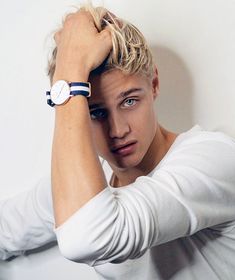 a young man with blonde hair wearing a watch