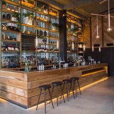 a bar with stools and shelves filled with bottles