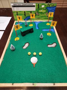 a golf game is set up on a table with markers and balls in the hole