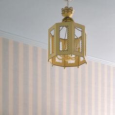 a light fixture hanging from the ceiling in a room with striped wall paper on the walls