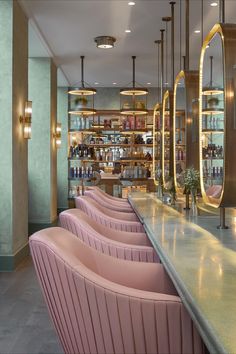 the bar is lined with pink velvet chairs