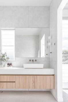 a bathroom with two sinks and a large mirror on the wall next to each other