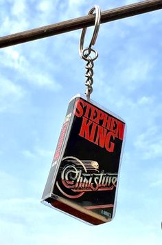 a metal keychain hanging from a pole with an advertisement for stephen king on it