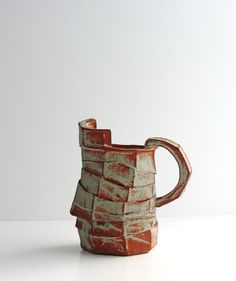 a brown and white vase sitting on top of a table