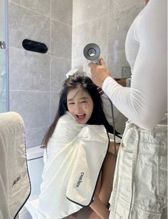 a woman is getting her hair brushed in the shower