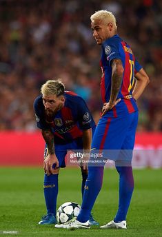 two soccer players standing next to each other on a field