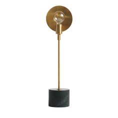 a black and gold floor lamp with a marble base on a white background the light is dim