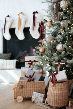 a christmas tree with presents in baskets under it