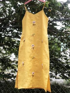 ❤ The yellow linen hand embroidered dress is very soft, skin friendly, breezy and comfortable.  ❤ Item description: - A lovely dress with embroidered daisy flowers motifs. - Suitable for hot summer. - Material: linen, button, embroidery threads. - Environmentally friendly. - This dress is very useful, go with any outfit, that can be used to go out, go shopping...    It is a perfect gift for yourself or your beloved.  ❤ Care instructions:      The best way to wash embroidery cloth is to put it in soapy water (with a mild detergent and cold water at 86 ºF/30oС) for 20 minutes. Try to not wash the item with other clothing that might cause damage, such as zippers, buttons or different colors. You wash it by hand, and if you have dirty patches on your garment, you can gently rub them, it's best Daisy Embroidered Dress, Dress With Hand Embroidery, Linen Dress Embroidery Ideas, Embroidery In Clothes, Yellow Beach Dress With Floral Embroidery, Linen Dress Embroidery, Embroidery Items, Yellow Embroidered Summer Beach Dress, Embroidery Dresses