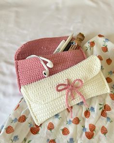 two crocheted purses sitting on top of a bed next to each other