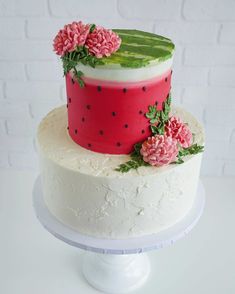 a white cake with pink flowers and green leaves