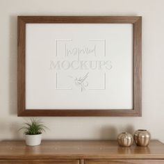 a wooden dresser with two vases and a framed photograph on the wall above it