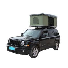 a black jeep with a green roof box on it's top and an awning