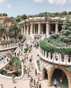 a group of people walking up and down stairs in front of a building with many trees