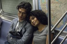 a man and woman sitting on a subway car