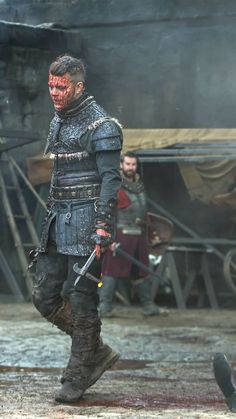 a man dressed in armor with blood on his face